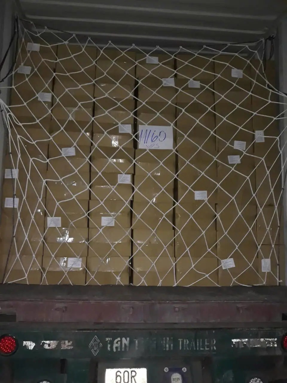 A loaded container of cashew cartons secured with a net