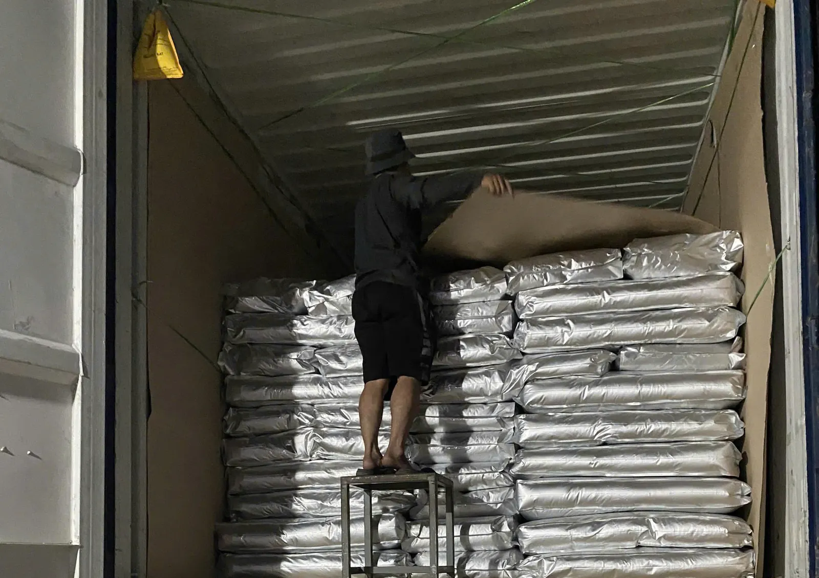 Lining a container loaded with vacuum-packed bags